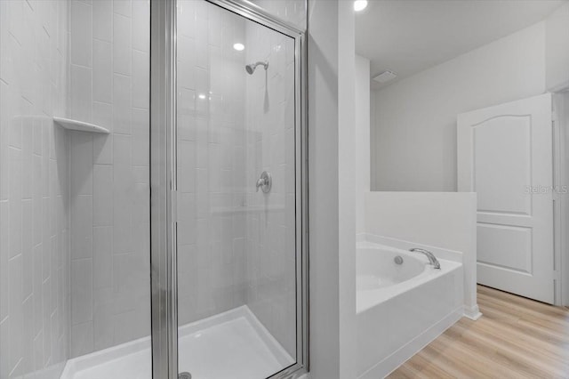 385 Begonia Ct, Poinciana, FL 34759 - full bath with a shower stall, a bath, and wood finished floors