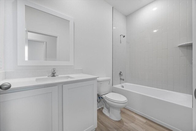 385 Begonia Ct, Poinciana, FL 34759 - bathroom with toilet, wood finished floors, vanity, and shower / bath combination