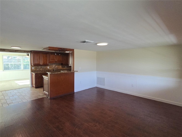 5130 Tilson Dr, New Port Richey, FL 34652 - kitchen with backsplash, a wainscoted wall, dark wood-style flooring, and visible vents