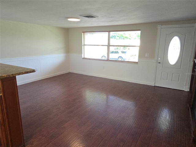 5130 Tilson Dr, New Port Richey, FL 34652 - foyer entrance with a wainscoted wall, dark wood-style floors, and visible vents