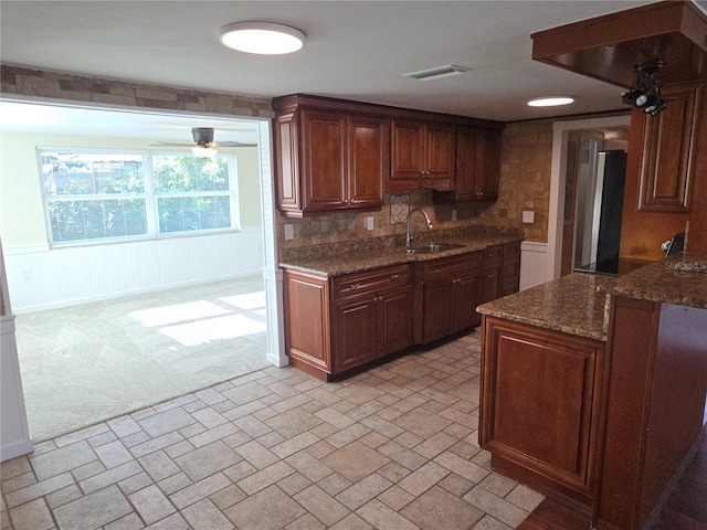 5130 Tilson Dr, New Port Richey, FL 34652 - kitchen featuring a sink, wainscoting, light colored carpet, visible vents, and dark stone counters
