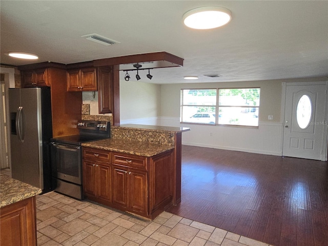5130 Tilson Dr, New Port Richey, FL 34652 - kitchen featuring visible vents, dark stone countertops, appliances with stainless steel finishes, and wainscoting