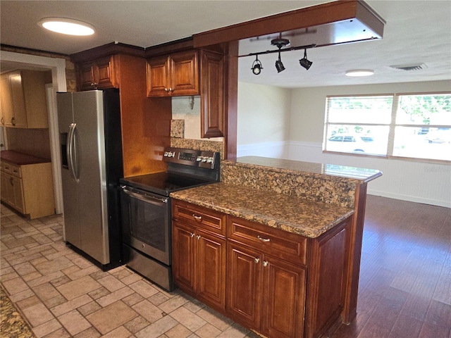 5130 Tilson Dr, New Port Richey, FL 34652 - kitchen with a peninsula, stainless steel appliances, dark stone countertops, and visible vents