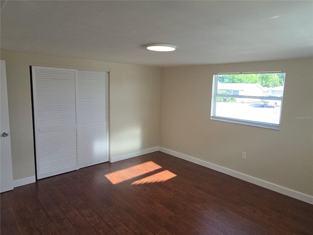 5130 Tilson Dr, New Port Richey, FL 34652 - unfurnished bedroom featuring baseboards, a closet, and dark wood-style flooring