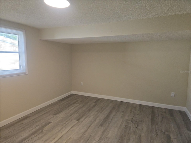 5130 Tilson Dr, New Port Richey, FL 34652 - spare room featuring dark wood finished floors, baseboards, and a textured ceiling