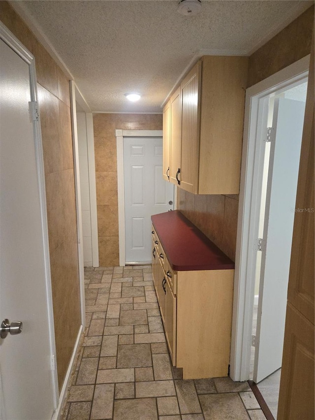5130 Tilson Dr, New Port Richey, FL 34652 - hallway featuring stone finish floor, tile walls, and a textured ceiling