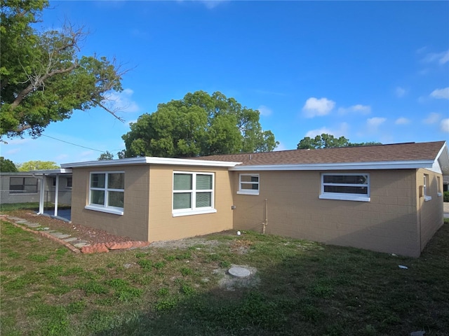 5130 Tilson Dr, New Port Richey, FL 34652 - view of side of property featuring a lawn, roof with shingles, and concrete block siding