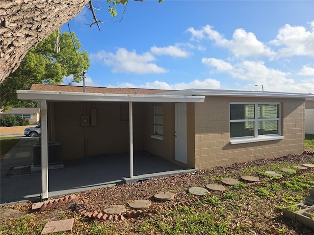 5130 Tilson Dr, New Port Richey, FL 34652 - back of house with central AC unit and concrete block siding