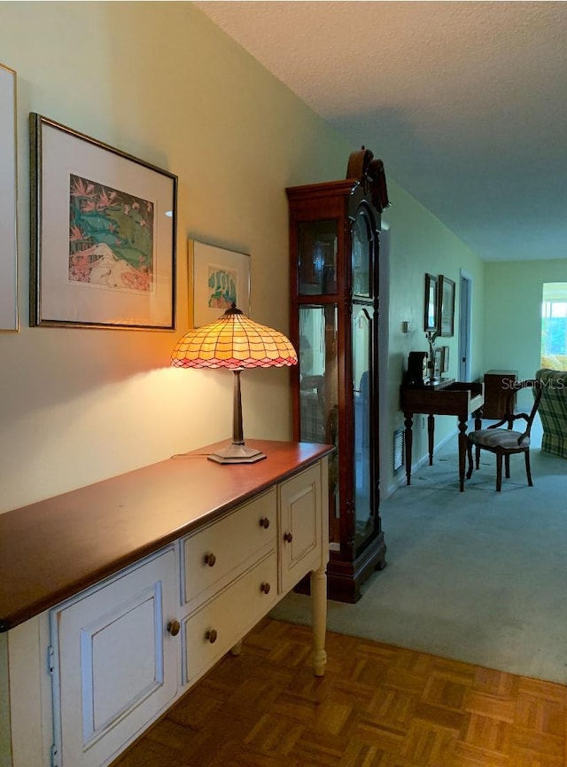 interior space featuring dark colored carpet and a textured ceiling