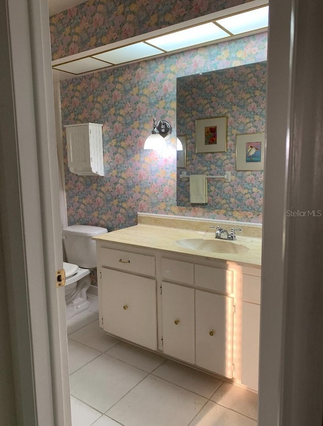 bathroom featuring wallpapered walls, toilet, tile patterned flooring, and vanity