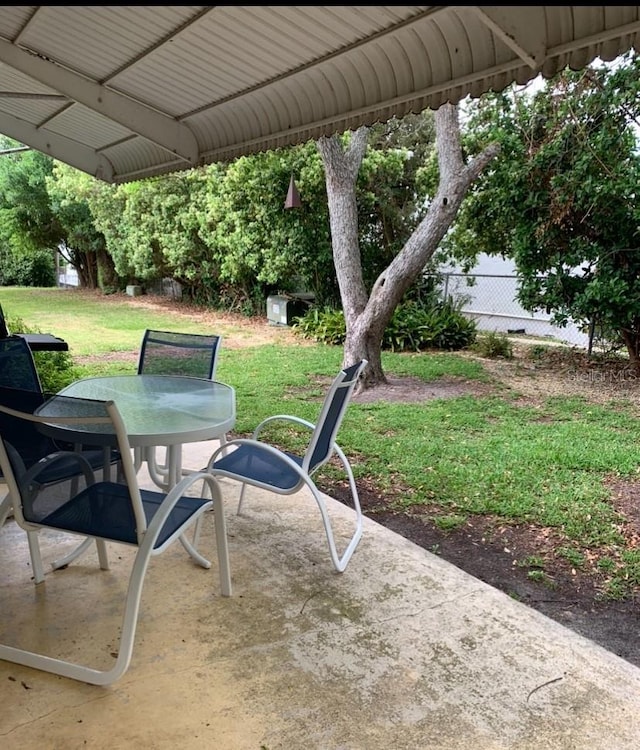 view of patio with outdoor dining space and fence