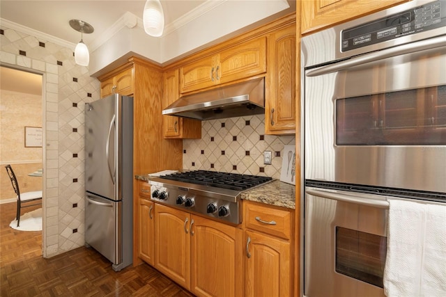 kitchen featuring appliances with stainless steel finishes, crown molding, under cabinet range hood, stone counters, and hanging light fixtures