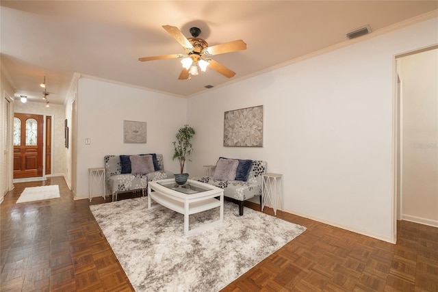 living room with a ceiling fan, ornamental molding, and baseboards