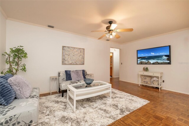 living room featuring ceiling fan, ornamental molding, and baseboards