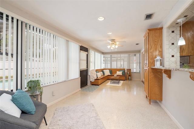 living area with baseboards, ceiling fan, speckled floor, and recessed lighting