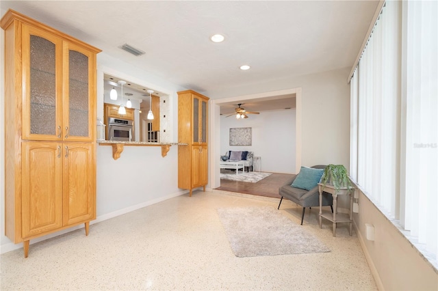 living area with baseboards, a ceiling fan, recessed lighting, and dark speckled floor