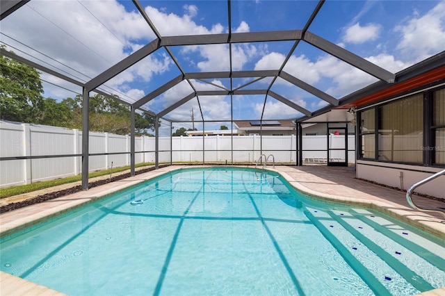 view of swimming pool featuring fence, a patio area, and glass enclosure