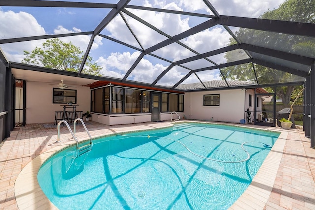 swimming pool featuring a patio area, a ceiling fan, and a lanai