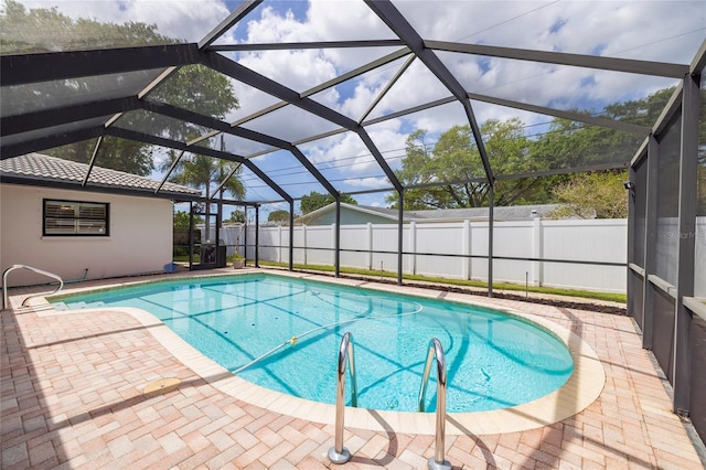 view of swimming pool with a fenced backyard, a patio, and a lanai