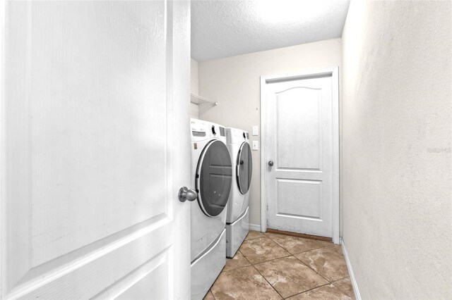 2404 Dovesong Trace Dr, Ruskin, FL 33570 - laundry area with separate washer and dryer, a textured ceiling, light tile patterned floors, and baseboards