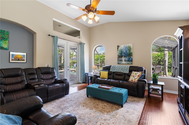 living area with vaulted ceiling, wood finished floors, a healthy amount of sunlight, and ceiling fan