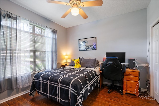 bedroom featuring hardwood / wood-style floors, ceiling fan, baseboards, and multiple windows