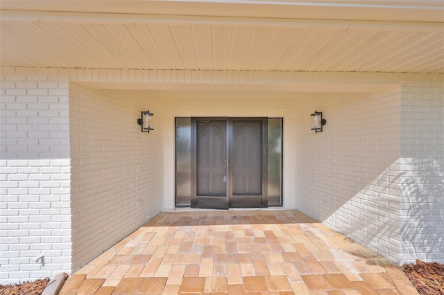 doorway to property featuring brick siding