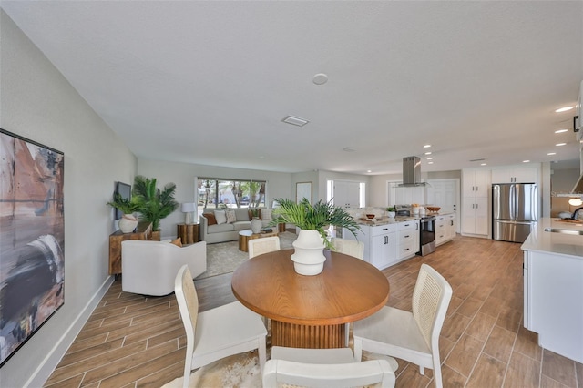 dining space with recessed lighting, visible vents, baseboards, and wood tiled floor