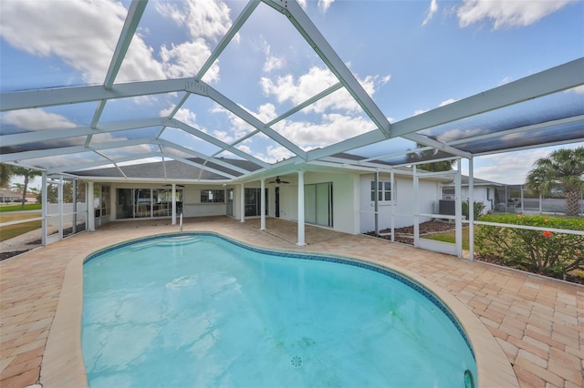 outdoor pool featuring a ceiling fan, a lanai, and a patio area
