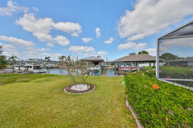 dock area with glass enclosure, a water view, boat lift, and a yard