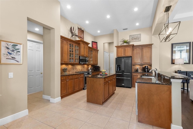 14817 Tudor Chase Dr, Tampa, FL 33626 - kitchen with appliances with stainless steel finishes, a sink, a center island, dark stone countertops, and brown cabinetry