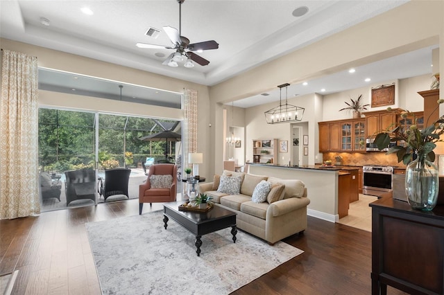 14817 Tudor Chase Dr, Tampa, FL 33626 - living room with ceiling fan, recessed lighting, hardwood / wood-style flooring, a high ceiling, and a tray ceiling