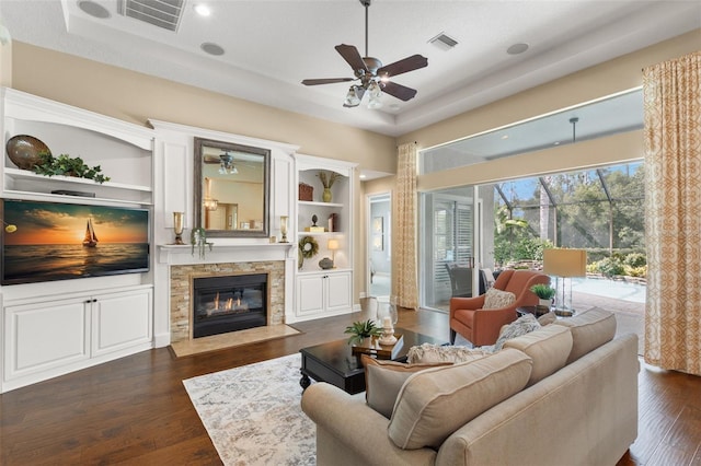 14817 Tudor Chase Dr, Tampa, FL 33626 - living area with ceiling fan, a stone fireplace, and dark wood-type flooring