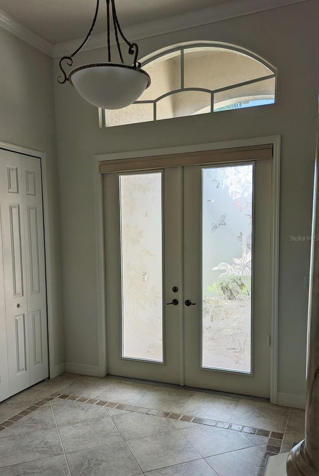 doorway to outside featuring baseboards, crown molding, and french doors