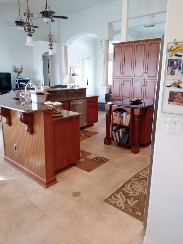 kitchen with a kitchen breakfast bar, decorative columns, a spacious island, arched walkways, and dishwasher