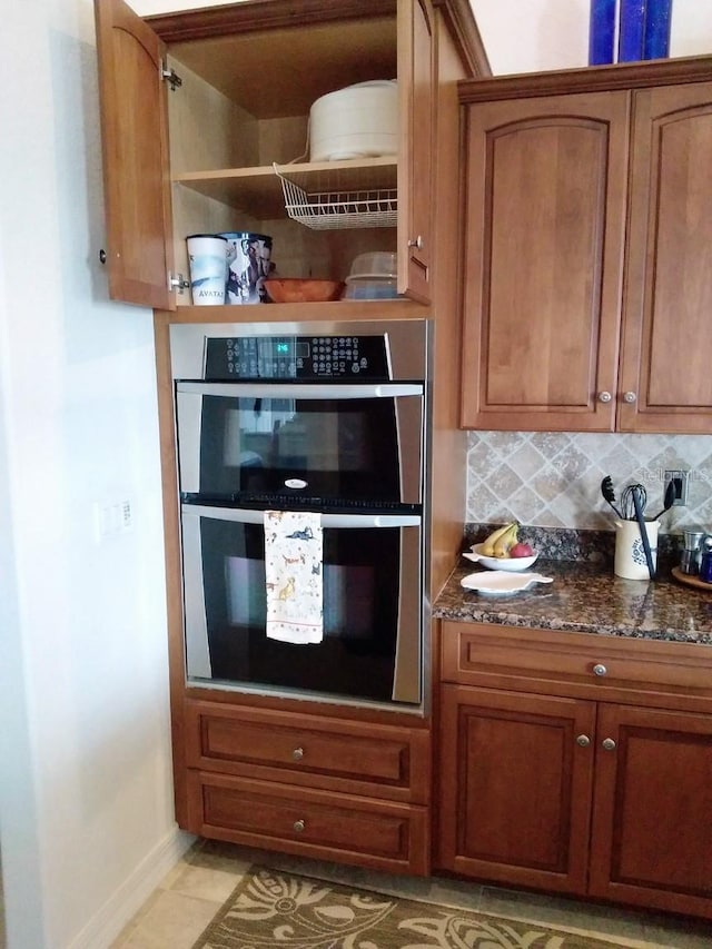 kitchen featuring double oven, brown cabinetry, and decorative backsplash