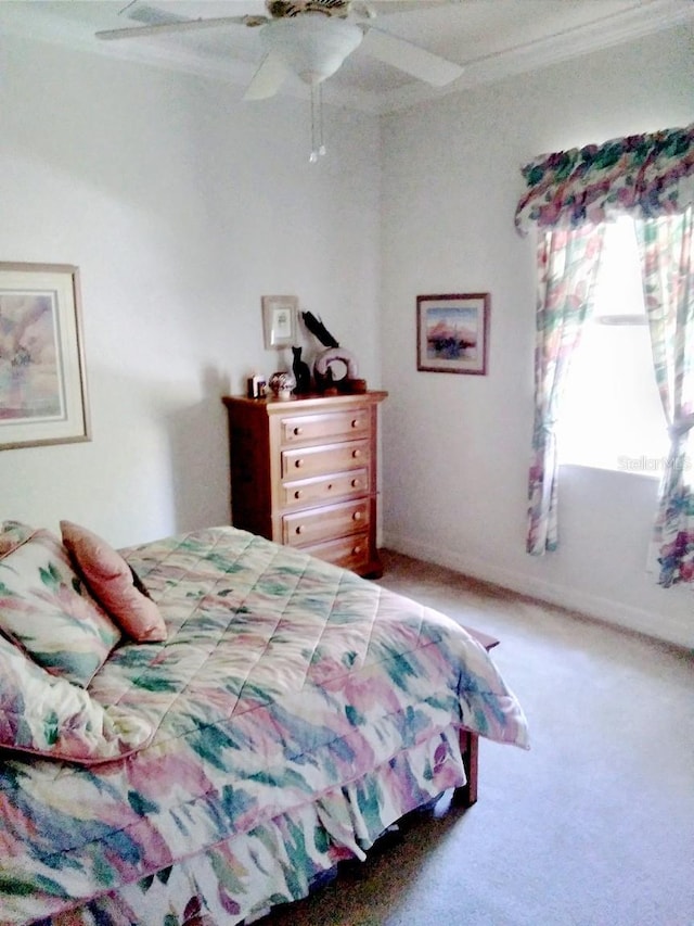 bedroom with a ceiling fan, ornamental molding, carpet, and baseboards