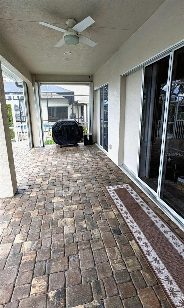 view of patio featuring a lanai and a ceiling fan