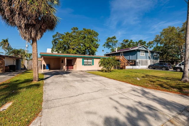 4126 Carson St NE, Saint Petersburg, FL 33703 - single story home featuring stucco siding, a carport, a front yard, fence, and concrete driveway