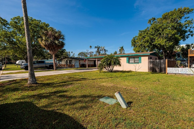 4126 Carson St NE, Saint Petersburg, FL 33703 - view of front of house with stucco siding, driveway, an attached carport, a front yard, and fence