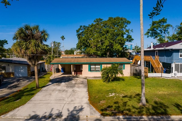 4126 Carson St NE, Saint Petersburg, FL 33703 - ranch-style house with stucco siding, fence, a front lawn, concrete driveway, and an attached carport