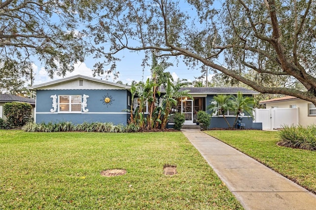 view of front of house with a front lawn, a gate, fence, and stucco siding