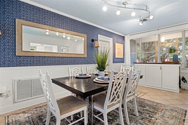 dining room with a wainscoted wall, light tile patterned flooring, visible vents, wallpapered walls, and ornamental molding