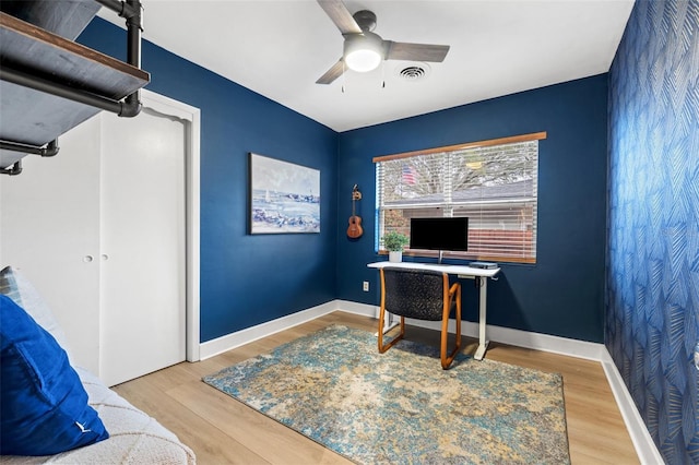 office area featuring visible vents, baseboards, ceiling fan, and wood finished floors