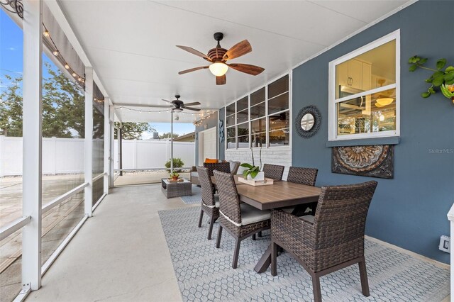 sunroom with outdoor dining area and ceiling fan