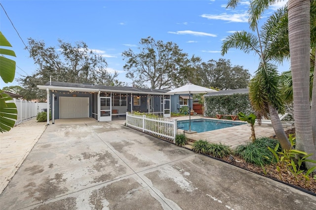 view of pool with a patio, a sunroom, fence, and a fenced in pool