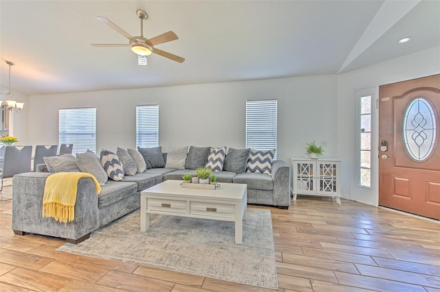 1666 Meadow Oak Ln, Tarpon Springs, FL 34689 - living room featuring vaulted ceiling, light wood-type flooring, healthy amount of natural light, a chandelier, and a ceiling fan