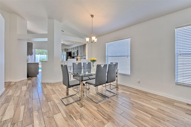 1666 Meadow Oak Ln, Tarpon Springs, FL 34689 - dining space featuring a chandelier, light wood-style floors, and vaulted ceiling