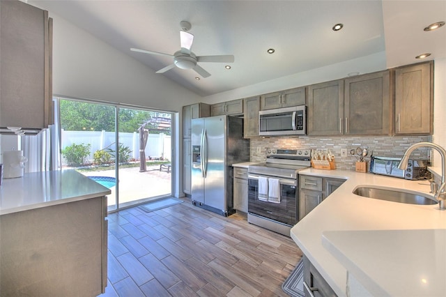 1666 Meadow Oak Ln, Tarpon Springs, FL 34689 - kitchen with appliances with stainless steel finishes, backsplash, vaulted ceiling, light countertops, and a ceiling fan