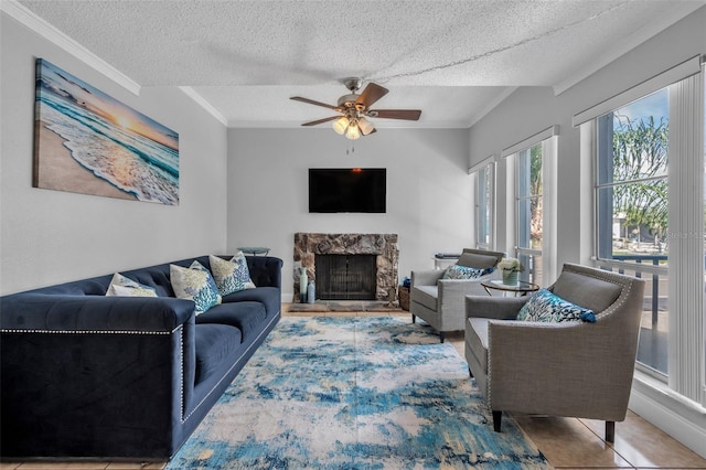 337 Rex Pl Unit E, Madeira Beach, FL 33708 - living area with a textured ceiling, a stone fireplace, a ceiling fan, and crown molding